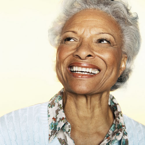 Older woman smiling with a dental crown from Peak Endodontics in Covington, WA