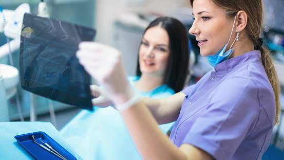 Dentist showing x-ray to patient