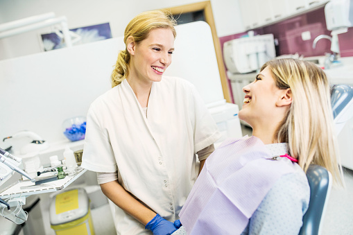 Doctor talking to patient sitting in dental chair