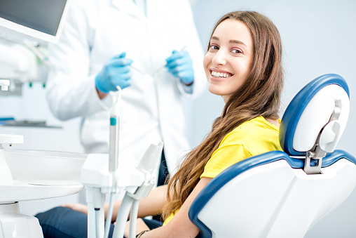 Happy patient sitting in dental chair