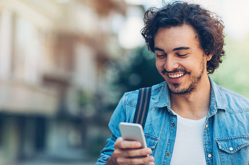 Smiling man looking at cell phone