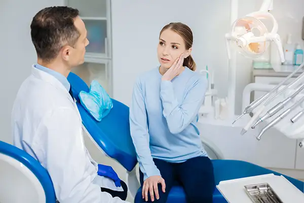 A woman with her doctor experiencing pain due to a knocked out tooth